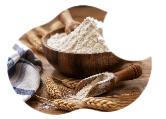 A wooden bowl of gluten-free flour with a scoop and wheat stalks